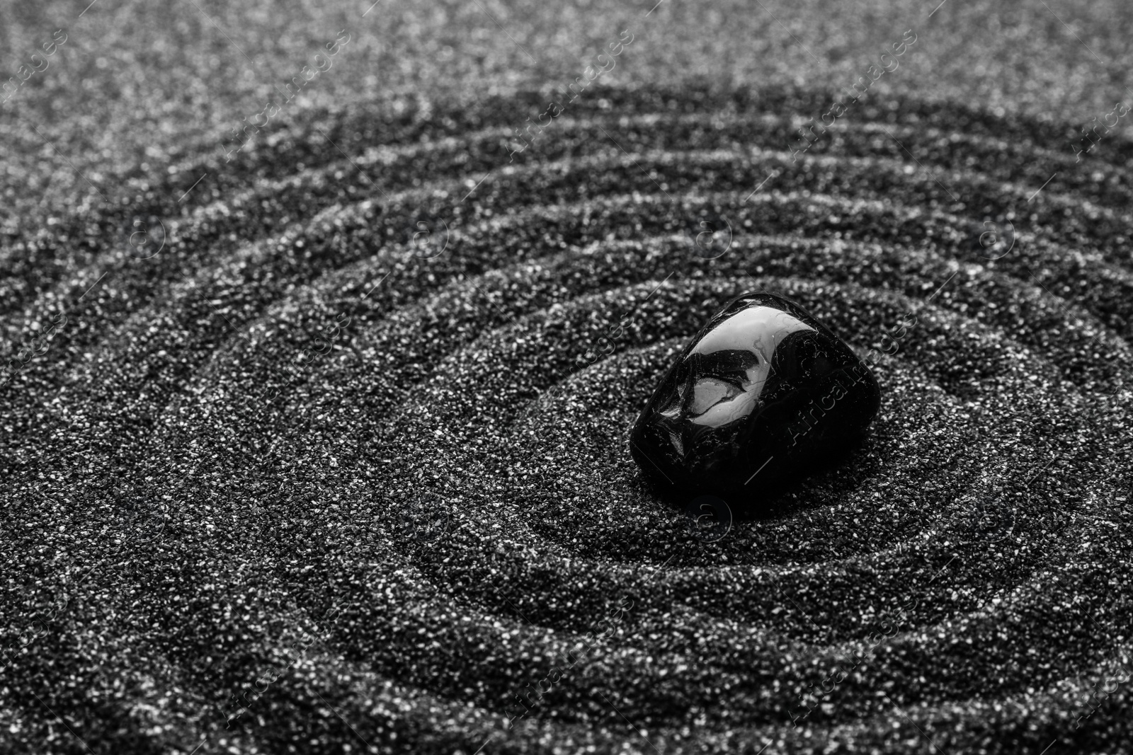 Photo of Black sand with stone and beautiful pattern. Zen concept