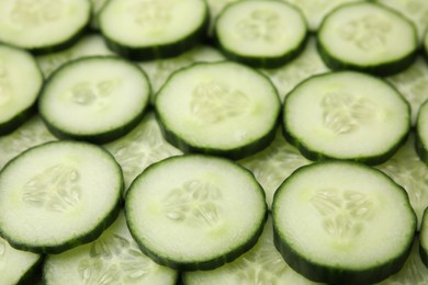 Photo of Fresh slices of cucumbers as background, closeup