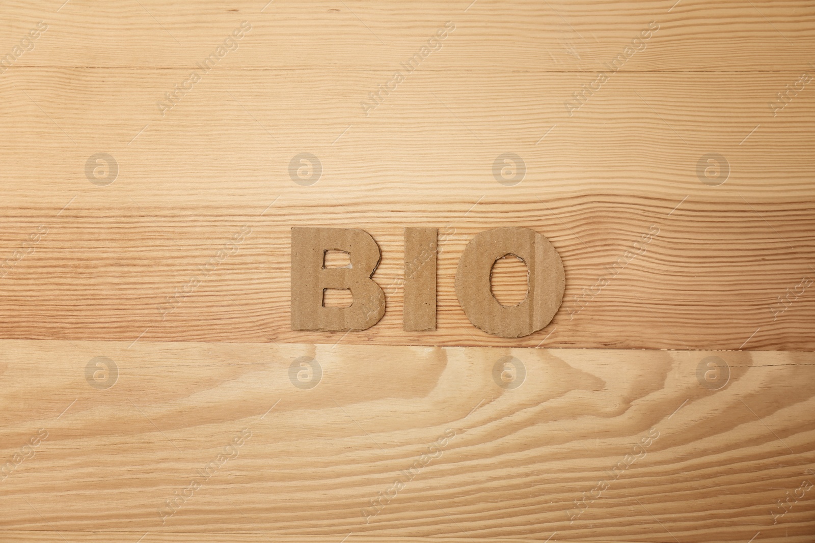 Photo of Word "Bio" made of cardboard letters on wooden background, top view