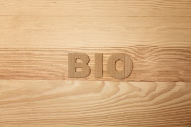 Photo of Word "Bio" madecardboard letters on wooden background, top view