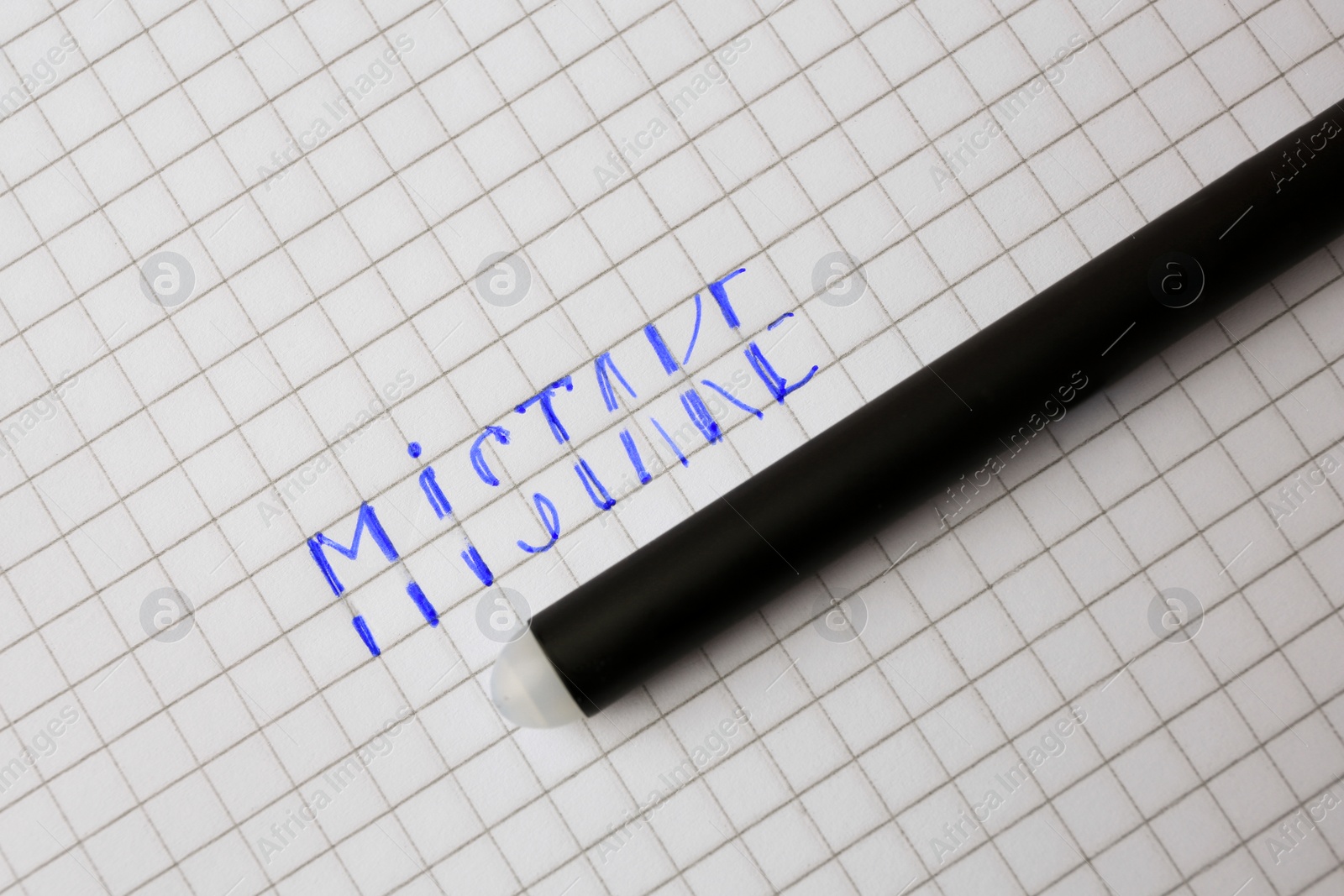 Photo of Word Mistake written on checkered paper with erasable pen, top view