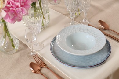 Photo of Stylish table setting with beautiful peonies and golden cutlery