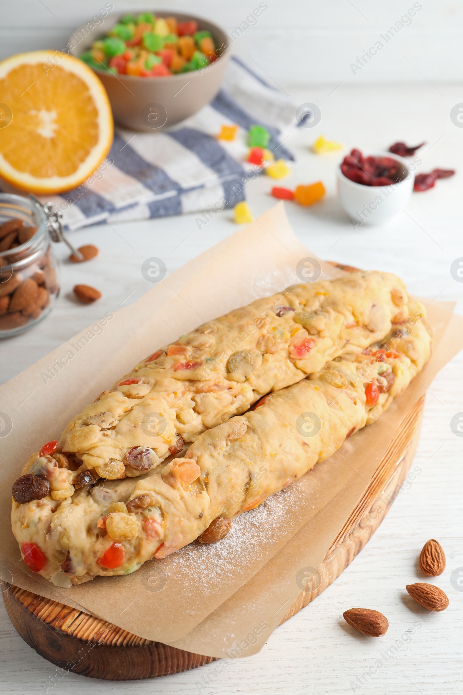 Photo of Unbaked Stollen with candied fruits and raisins on white wooden table