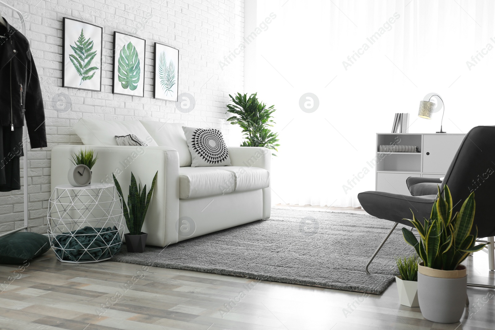 Photo of Comfortable white sofa in modern room. Interior design