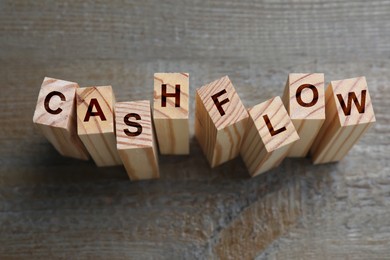 Image of Blocks with phrase Cash FLow on black wooden background, above view