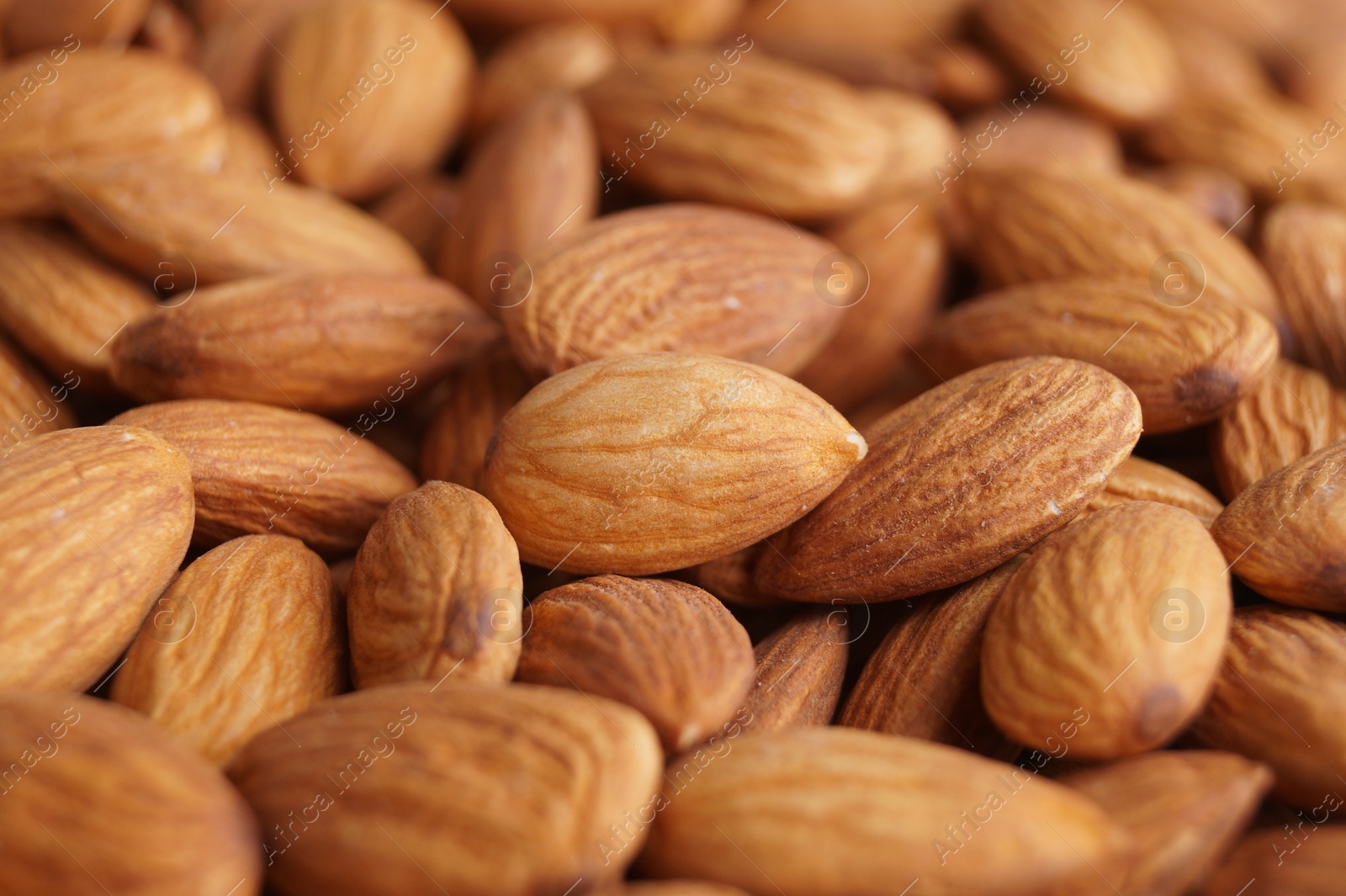 Photo of Pile of delicious raw ripe almonds, closeup