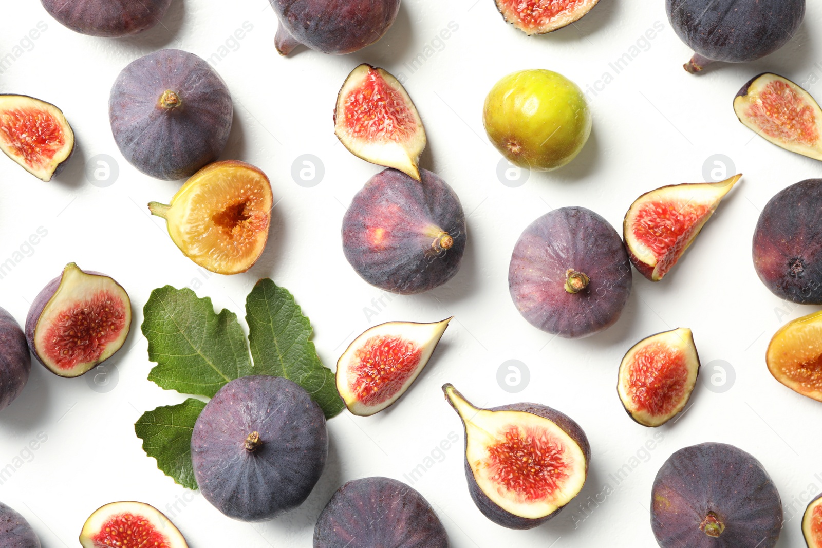 Photo of Tasty fresh purple and green figs on white table, flat lay