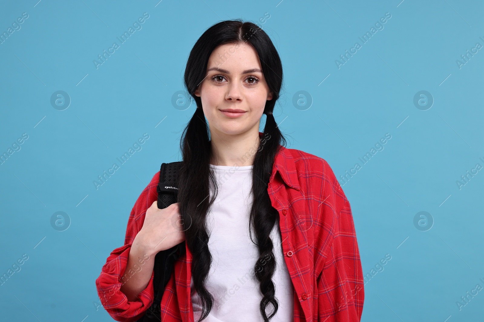 Photo of Student with backpack on light blue background