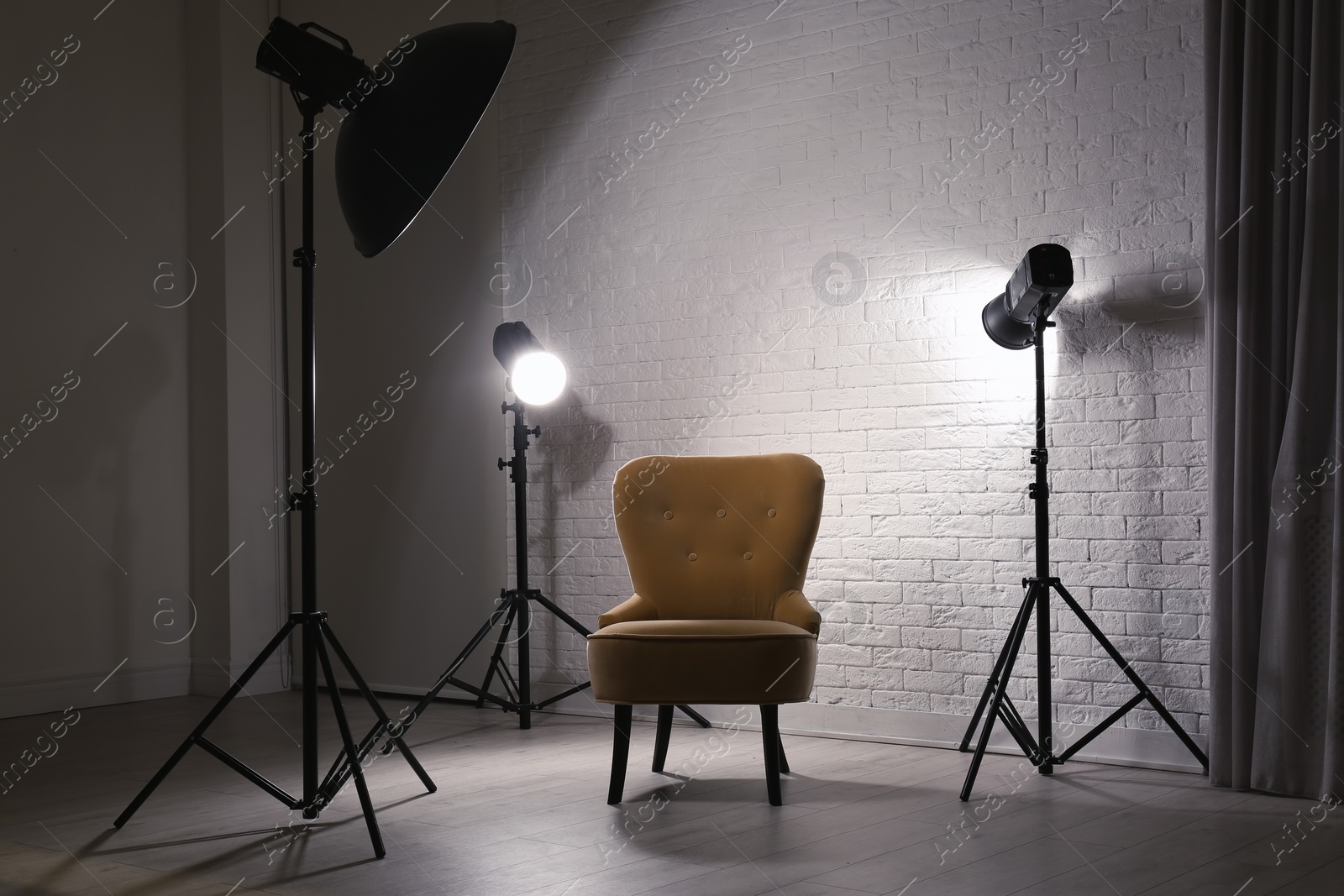 Photo of Interior of modern photo studio with professional lighting equipment and armchair