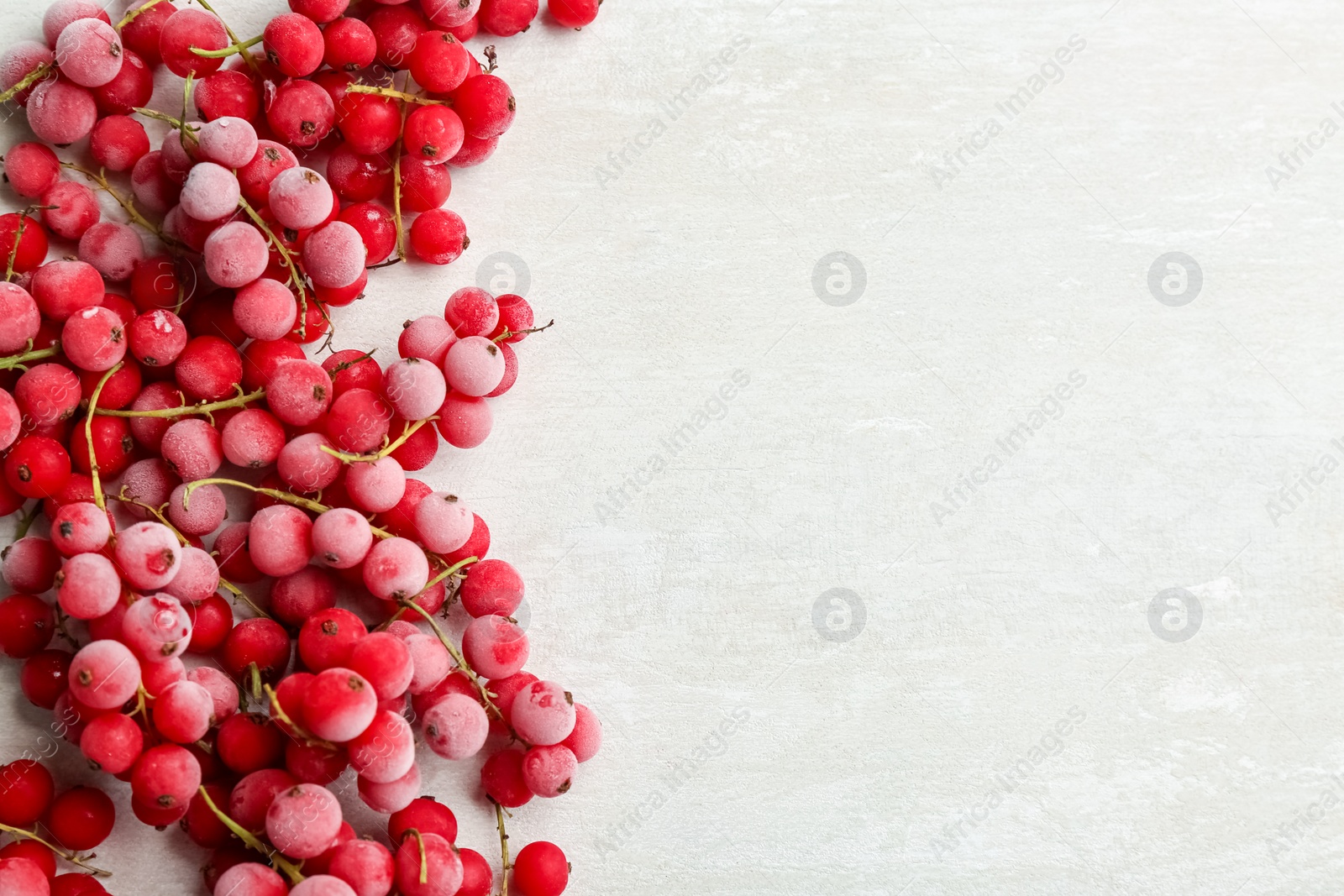 Photo of Tasty frozen red currants on white table, flat lay. Space for text