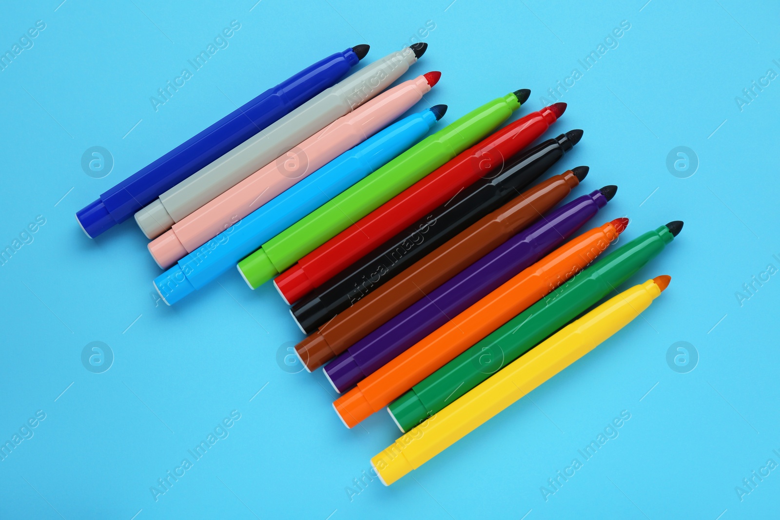 Photo of Many different colorful markers on light blue background, flat lay