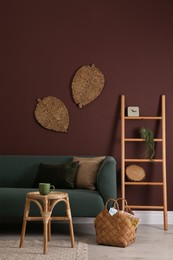 Photo of Comfortable wooden stool near sofa in living room