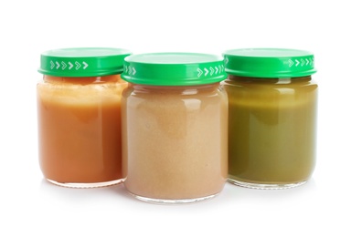 Jars with healthy baby food on white background