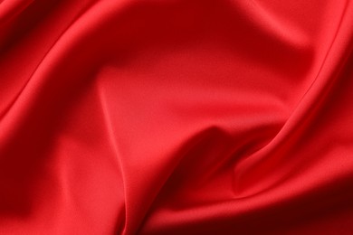 Photo of Crumpled red silk fabric as background, top view