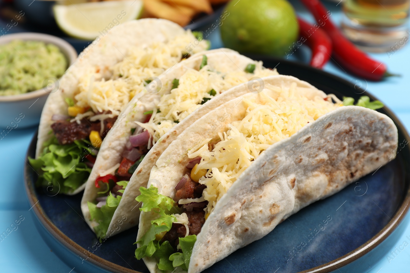 Photo of Delicious tacos with meat and vegetables on table, closeup