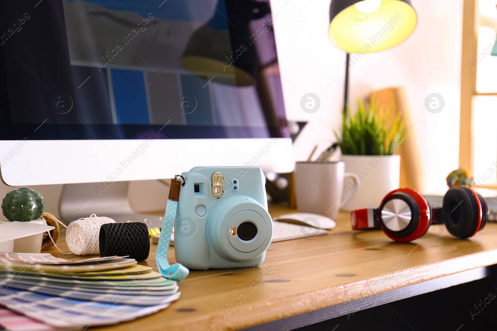 Photo of Digital camera and color palette on table in studio. Modern designer's workplace