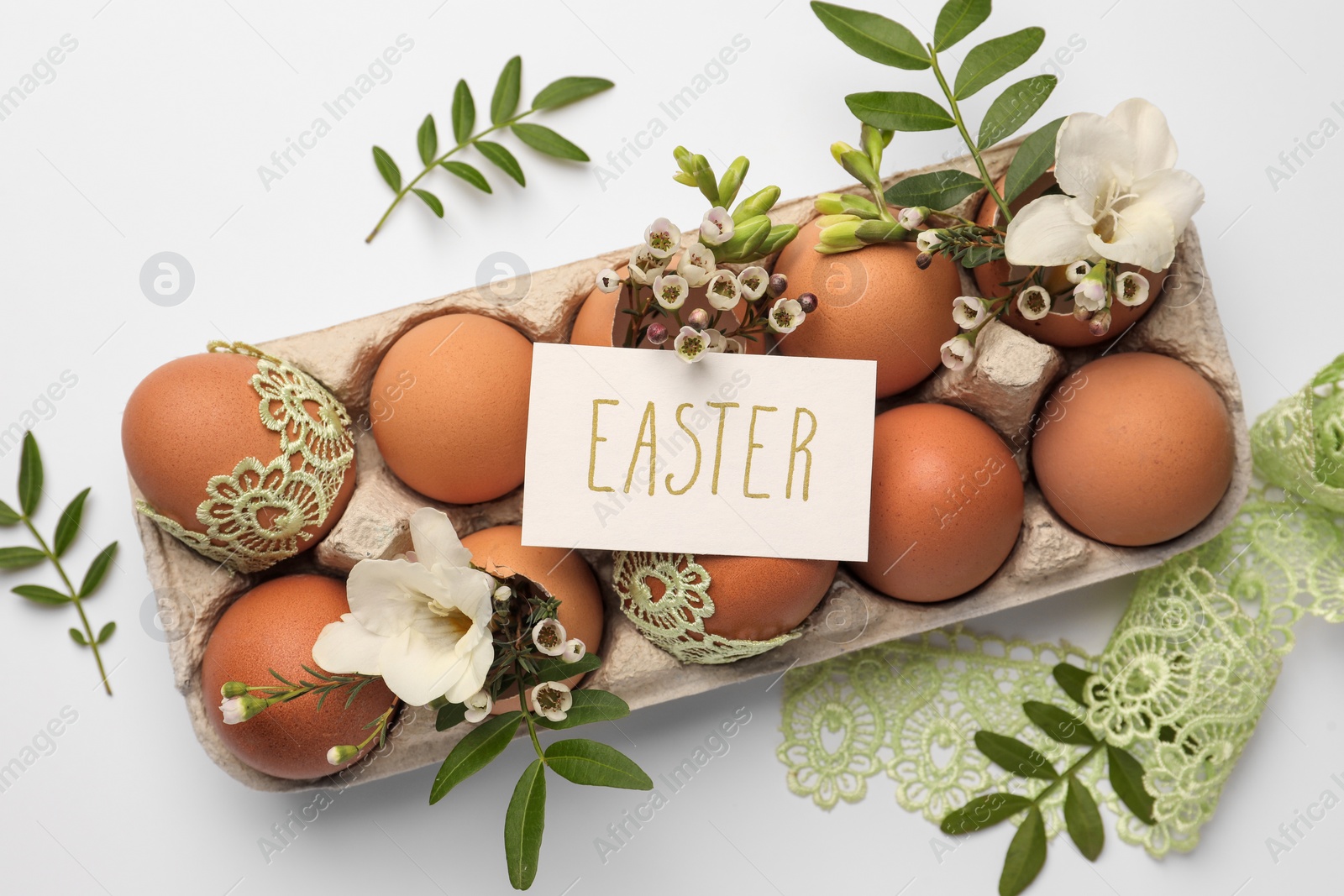 Photo of Card with word Easter, eggs and green twigs on white background, flat lay