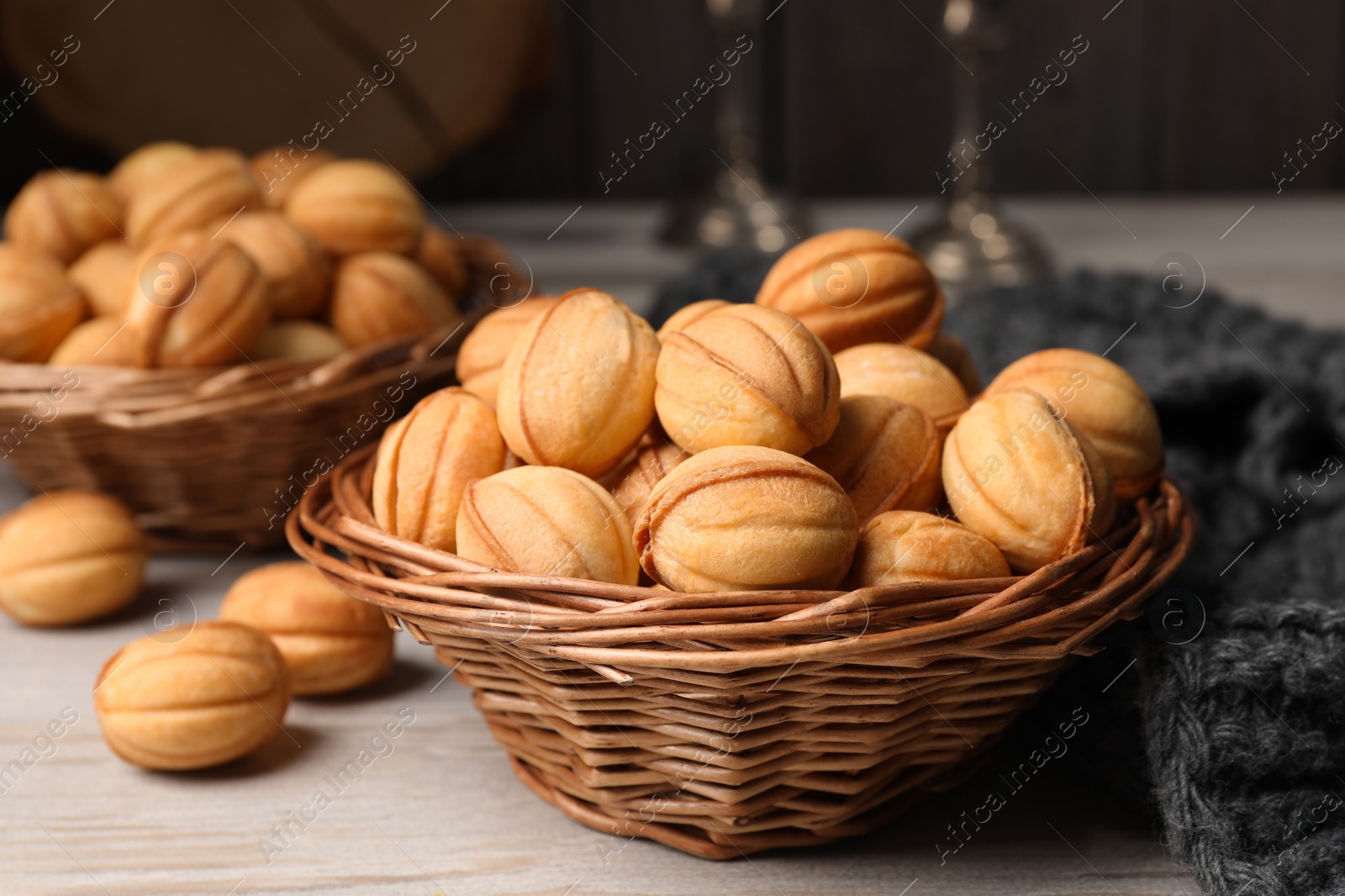 Photo of Bowls of delicious nut shaped cookies on white wooden table, closeup