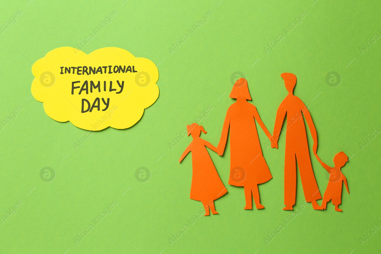 Photo of Paper cutout and card with text International family day on light green background, flat lay