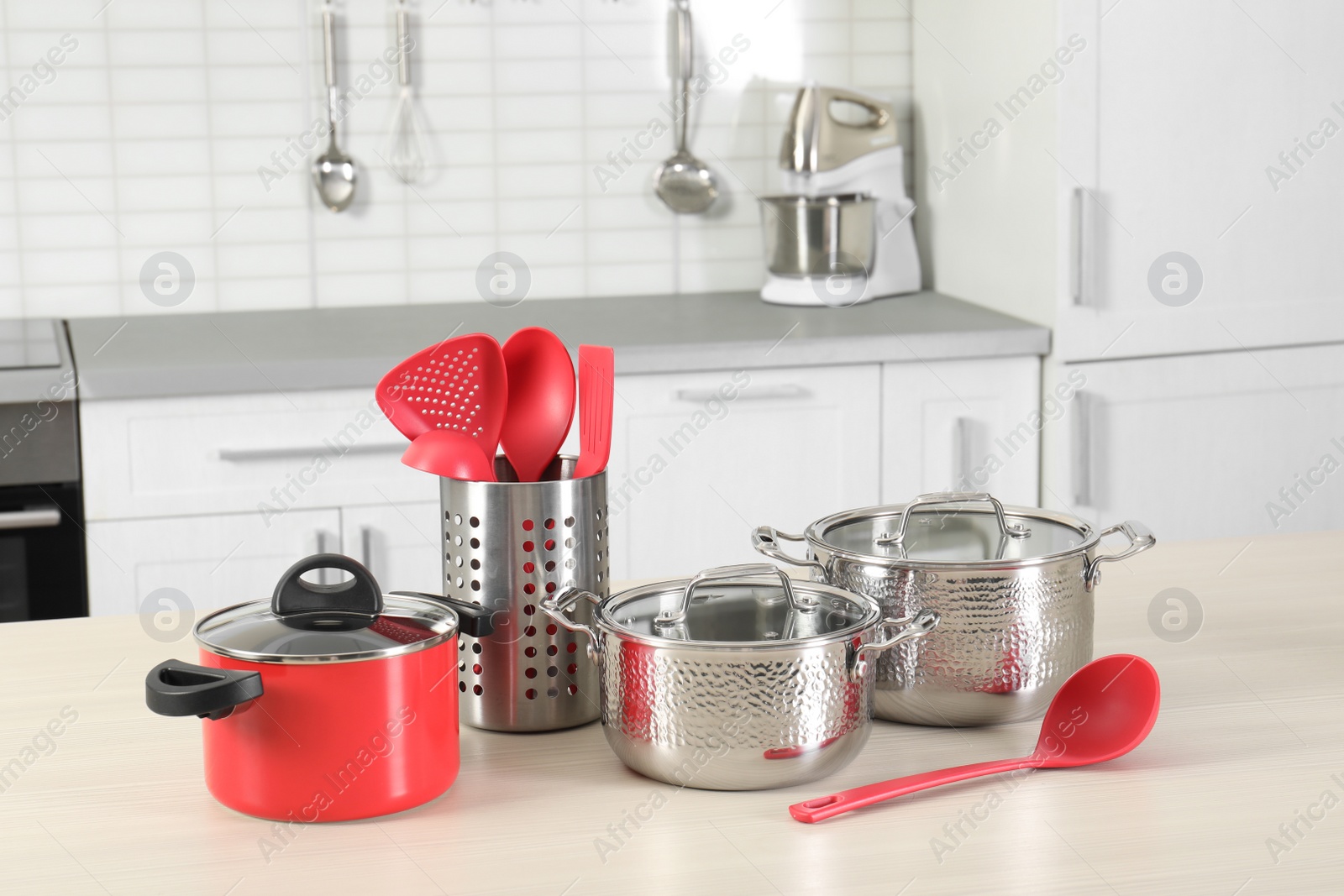 Photo of Set of clean cookware and utensils on table in kitchen