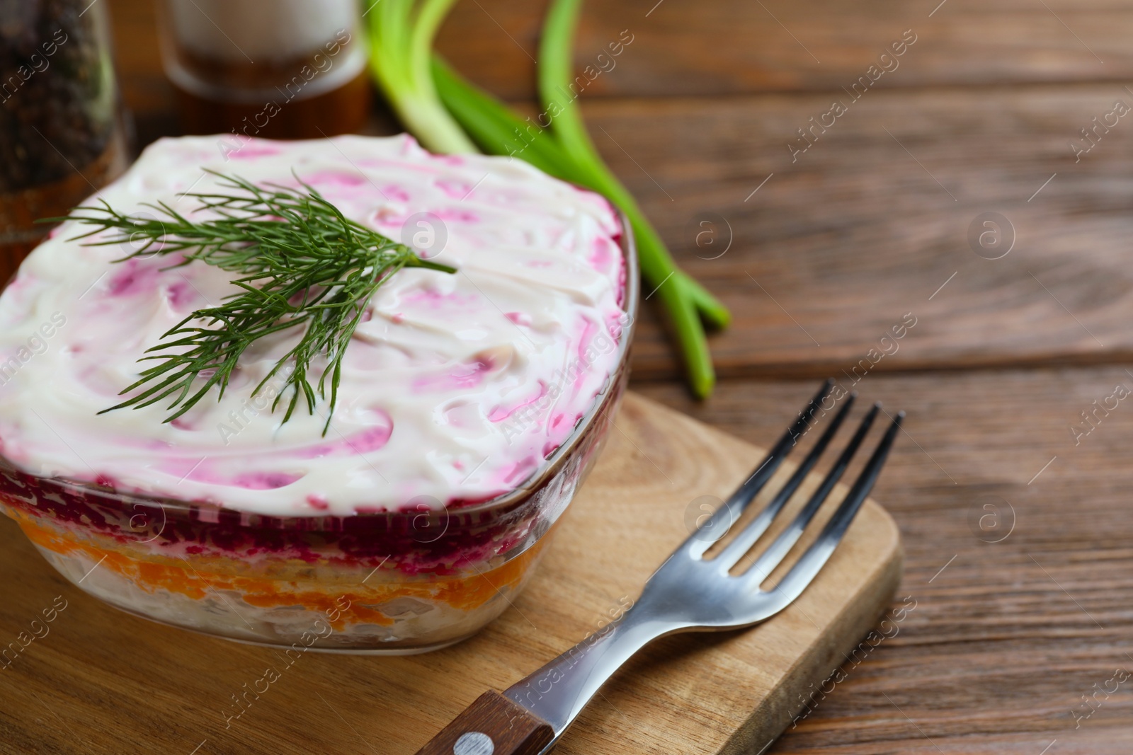Photo of Herring under fur coat on wooden table, space for text. Traditional Russian salad