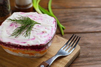 Herring under fur coat on wooden table, space for text. Traditional Russian salad