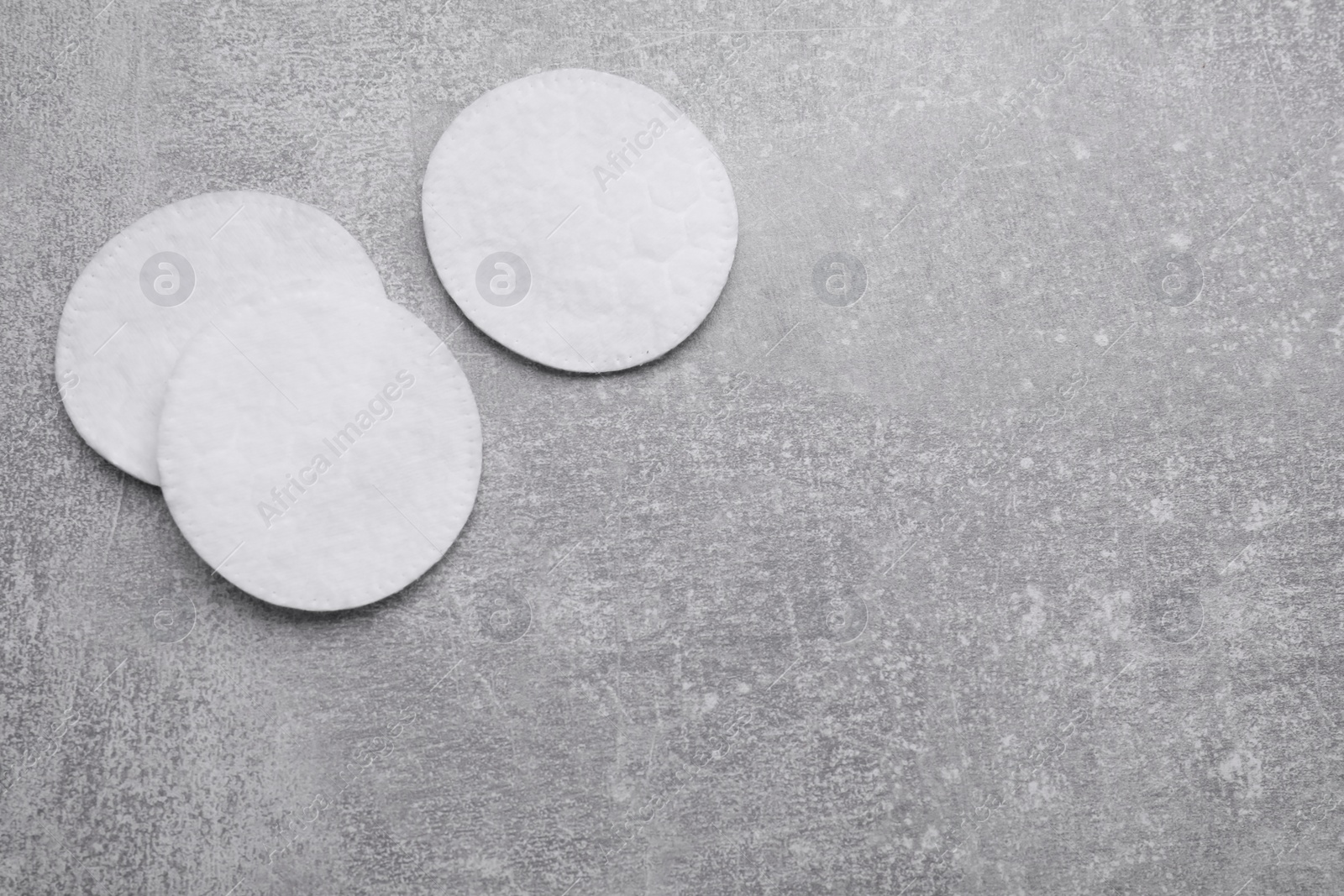 Photo of Clean cotton pads on light grey background, flat lay. Space for text