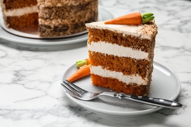 Photo of Piece of sweet carrot cake with delicious cream on white marble table