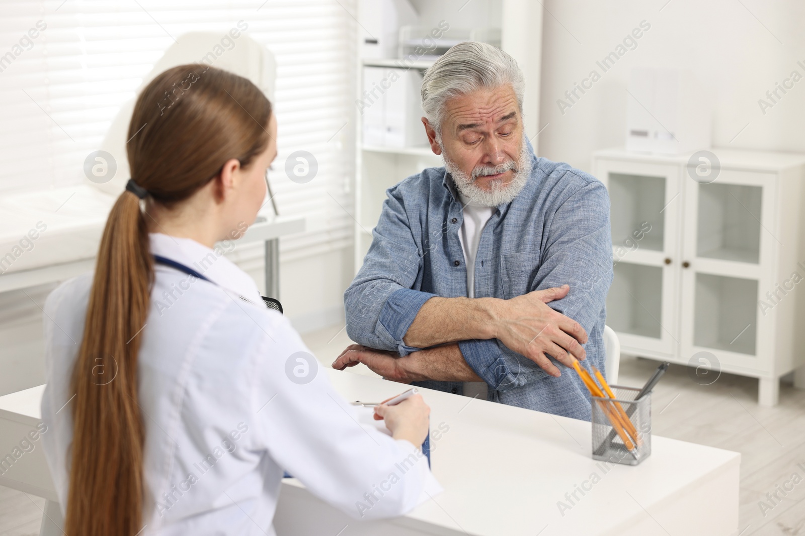 Photo of Arthritis symptoms. Doctor consulting patient with elbow pain in hospital