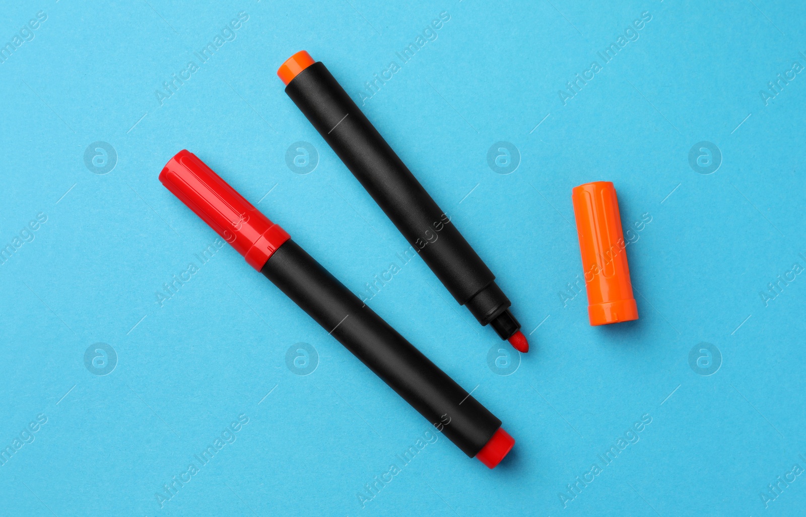 Photo of Bright color markers on light blue background, flat lay
