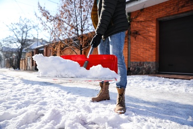 Photo of Person shoveling snow outdoors on winter day, closeup