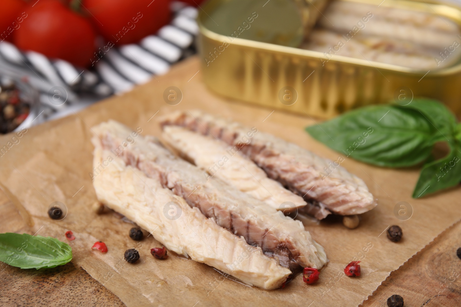 Photo of Canned mackerel fillets served on wooden board, closeup