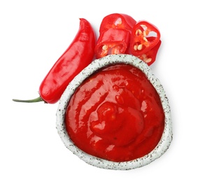 Photo of Bowl with red sauce and fresh chili peppers isolated on white, top view