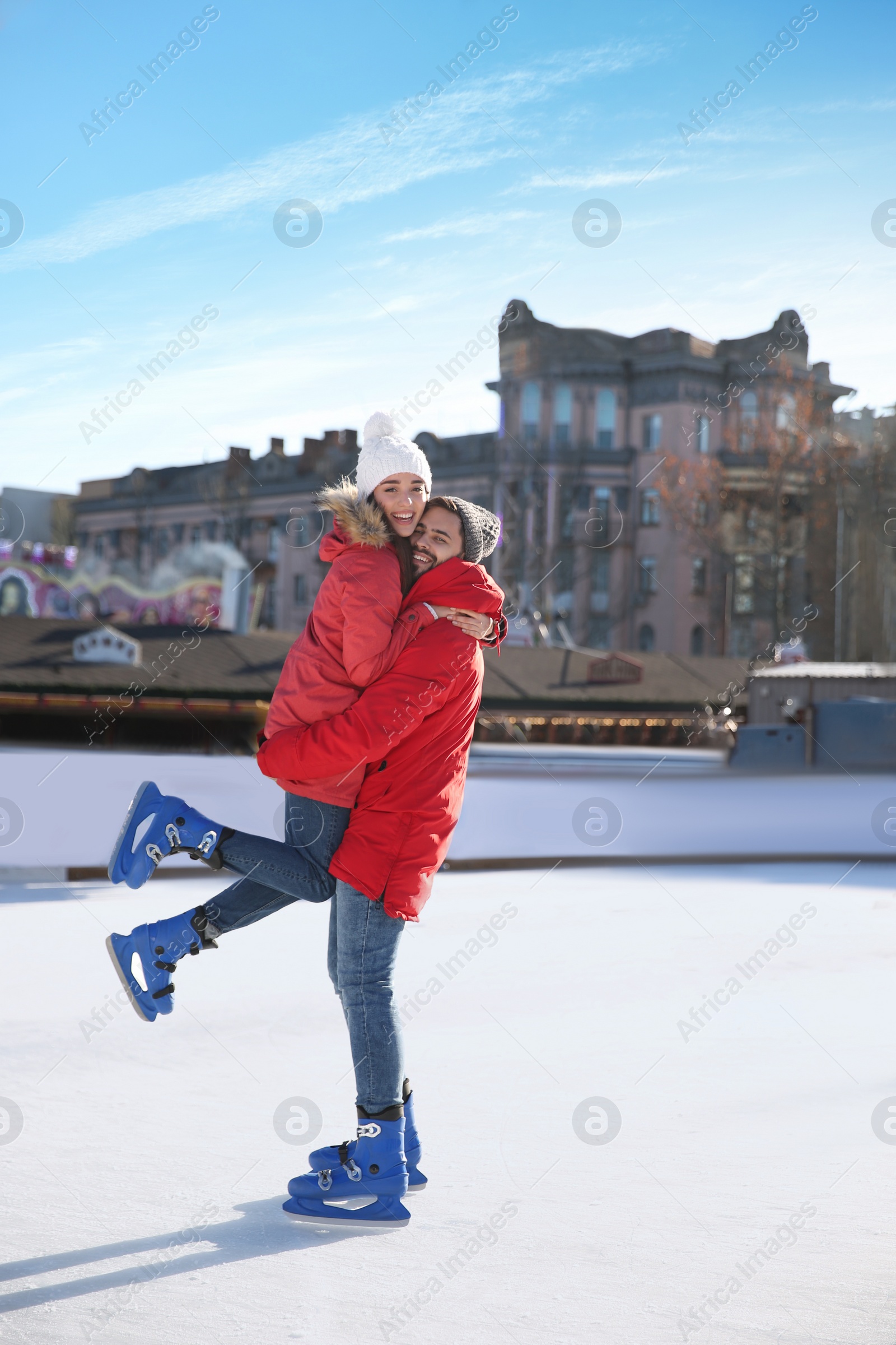 Image of Lovely couple spending time together at outdoor ice skating rink