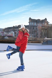 Image of Lovely couple spending time together at outdoor ice skating rink