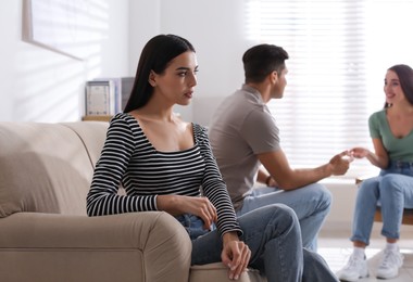 Unhappy woman feeling jealous while couple spending time together at home