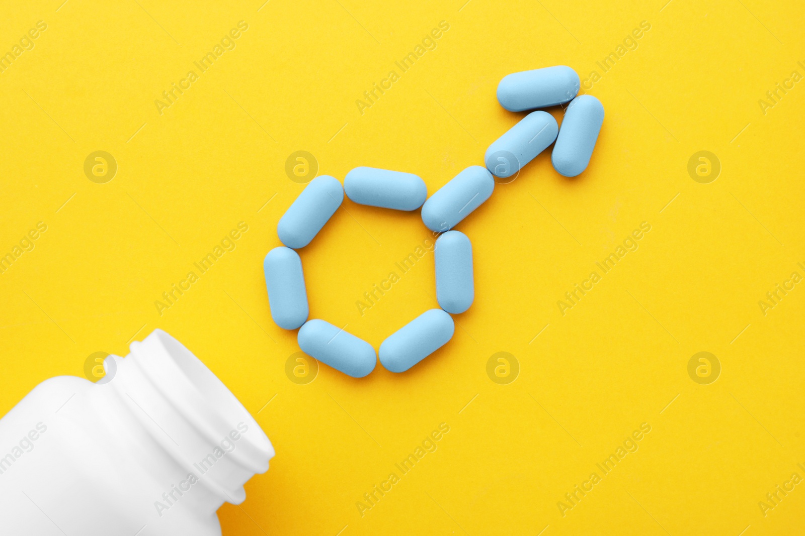 Photo of Male sign made of pills and medical bottle on orange background, flat lay. Potency problem