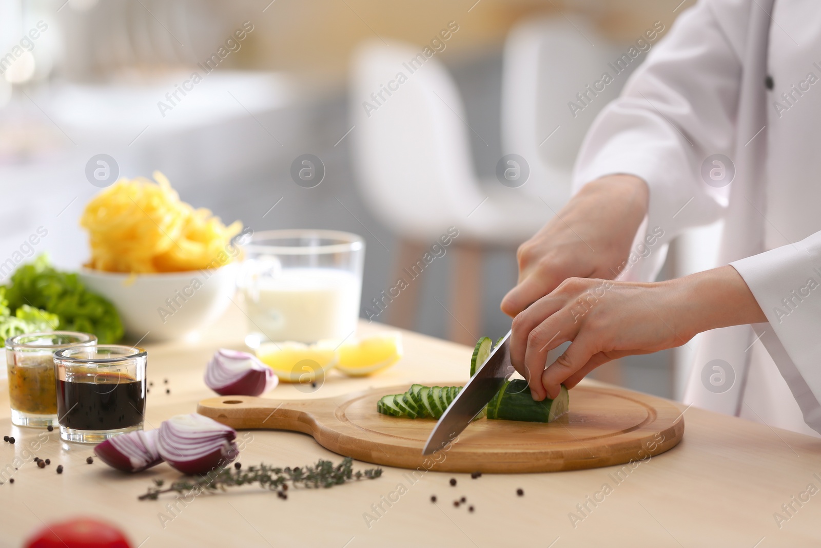 Photo of Female chef cooking food at kitchen table, closeup