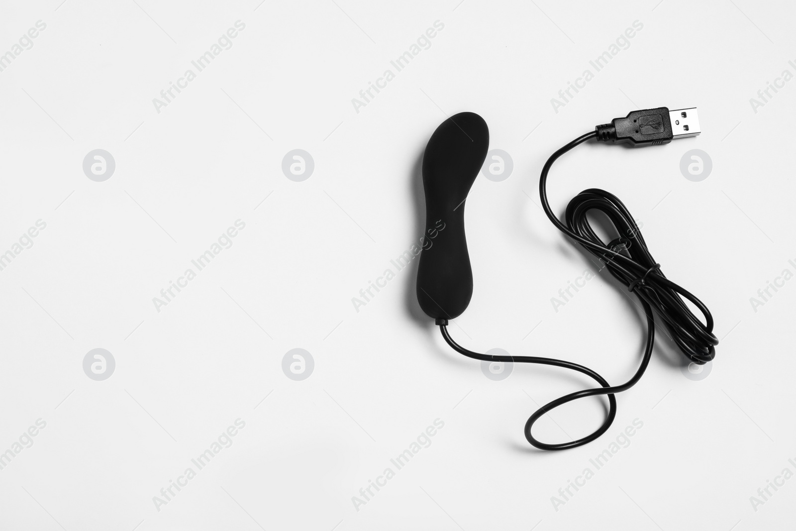 Photo of Black vibrator on white background, top view. Sex toy