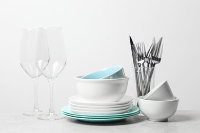 Photo of Beautiful ceramic dishware, glasses and cutlery on light grey table