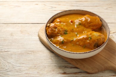 Photo of Tasty chicken curry on wooden table, closeup. Space for text