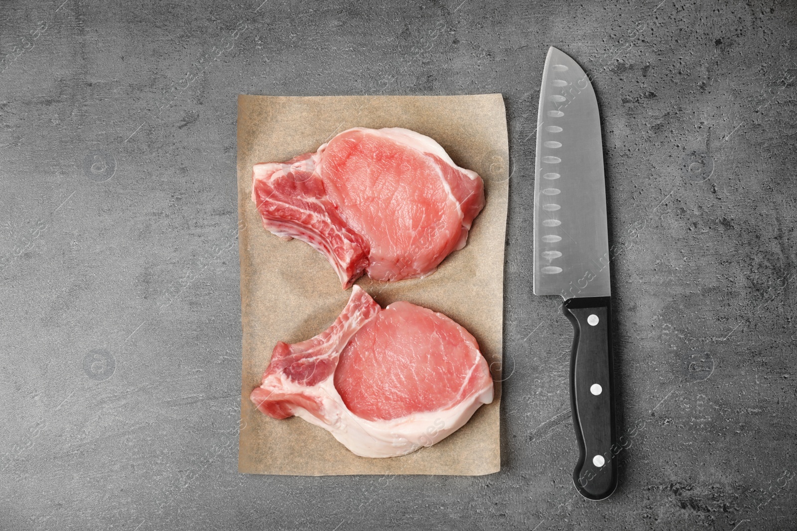 Photo of Flat lay composition with raw meat and knife on grey background