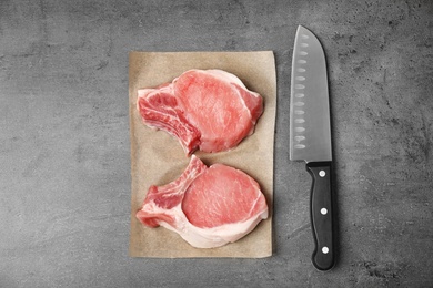 Photo of Flat lay composition with raw meat and knife on grey background