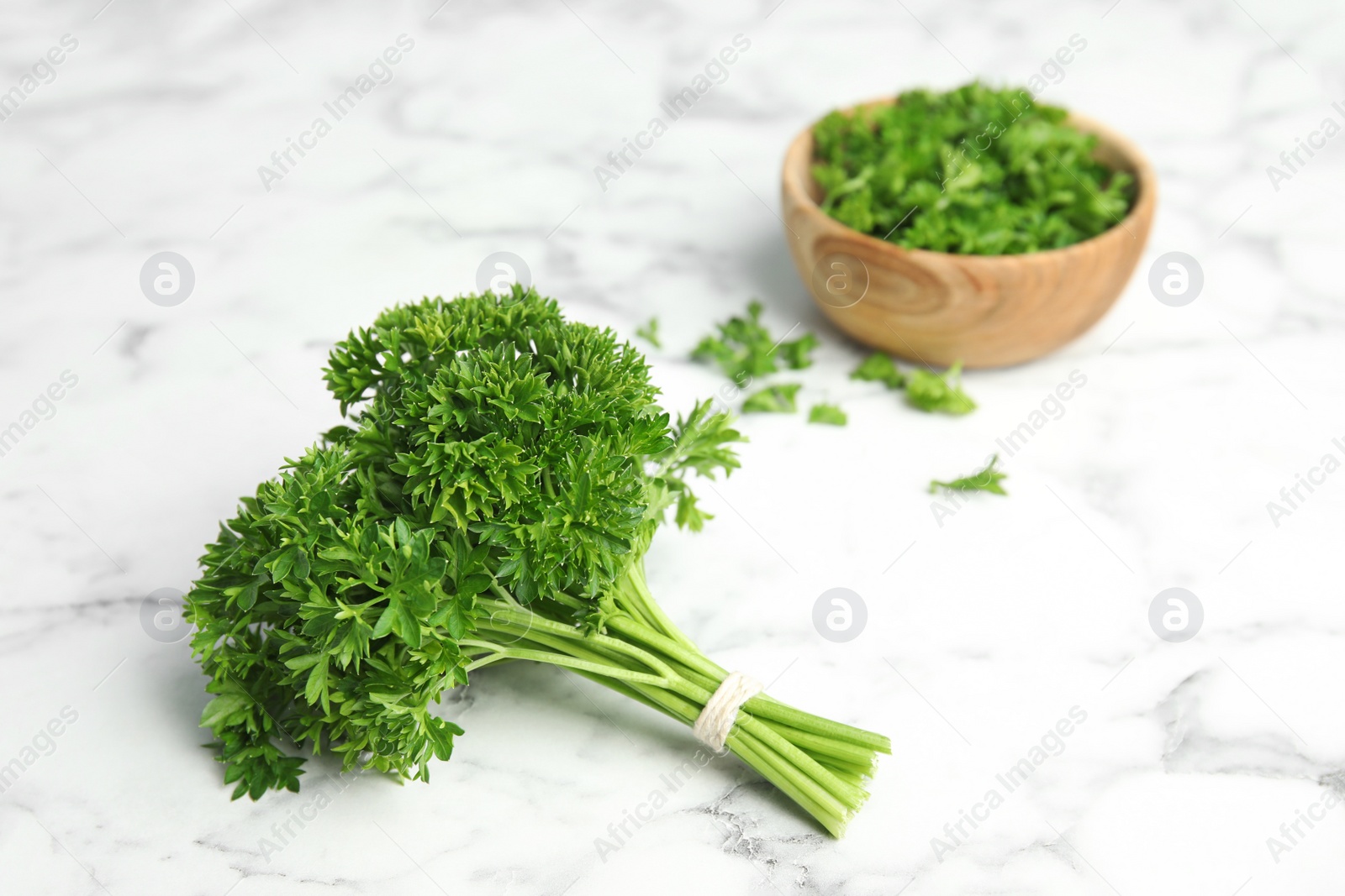 Photo of Fresh green parsley on marble table, space for text