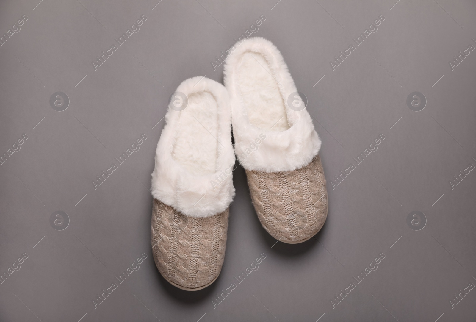 Pair of beautiful soft slippers on grey background, top view Photo of Pair of beautiful soft slippers on grey background, top view
