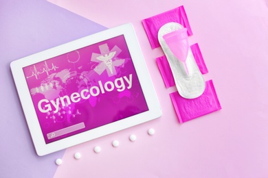 Photo of Flat lay composition with tablet, pills and feminine hygiene items on color background. Gynecological care