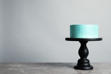 Photo of Fresh delicious birthday cake on stand against grey background. Space for text