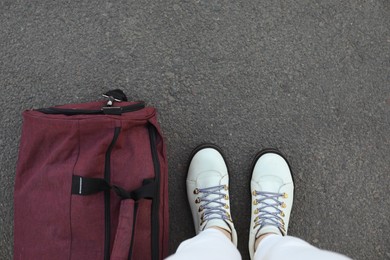 Photo of Woman with bag standing on asphalt, top view. Space for text