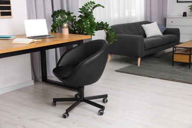 Photo of Stylish room interior with comfortable office chair, desk and houseplant