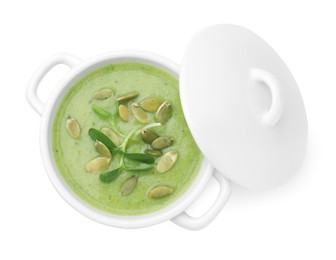 Delicious broccoli cream soup with pumpkin seeds isolated on white, top view